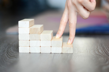 Hand climbing stairs made by wooden blocks 