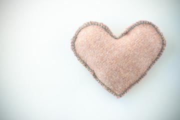 Pink handmade textile fabric heart on white background closeup