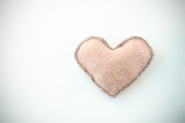 Pink handmade textile fabric heart on white background closeup