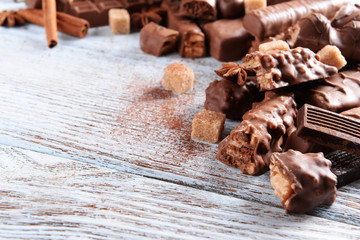 Chocolate sweets with powder on wooden background