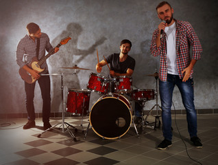 Musicians playing musical instruments and singing songs in a studio