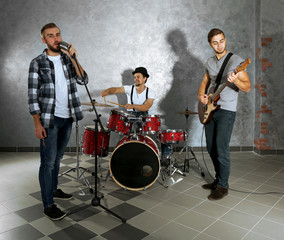 Musicians playing musical instruments and singing songs in a studio