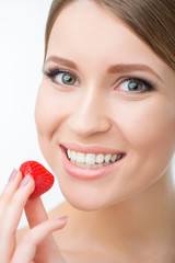 Smiling woman eating strawberry 