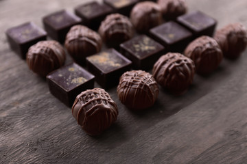 Delicious chocolate candies on wooden background