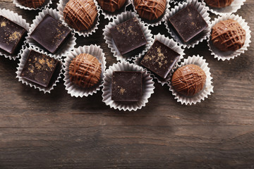 Assorted chocolate candies on wooden background