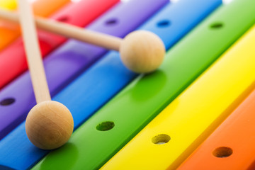 Rainbow colored wooden toy xylophone against white background