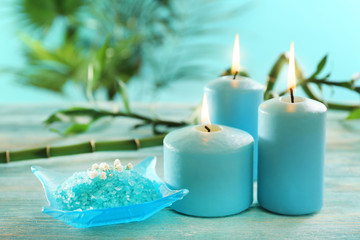 Obraz na płótnie Canvas Blue candles with spa salt and bamboo on table