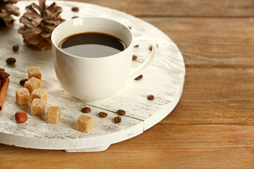 Cup of coffee with sugar and cinnamon on white wooden mat
