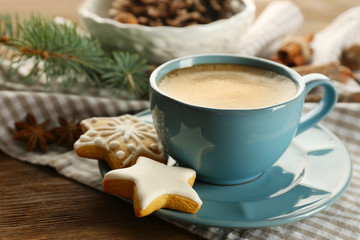 Cup of coffee with star shaped biscuits and Christmas tree branch on napkin