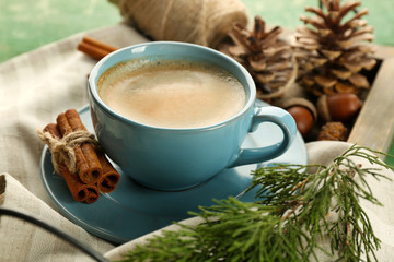 Cup of coffee on napkin on wooden tray