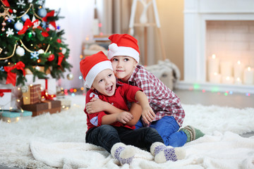 Obraz na płótnie Canvas Two cute small brothers hugging on Christmas tree background