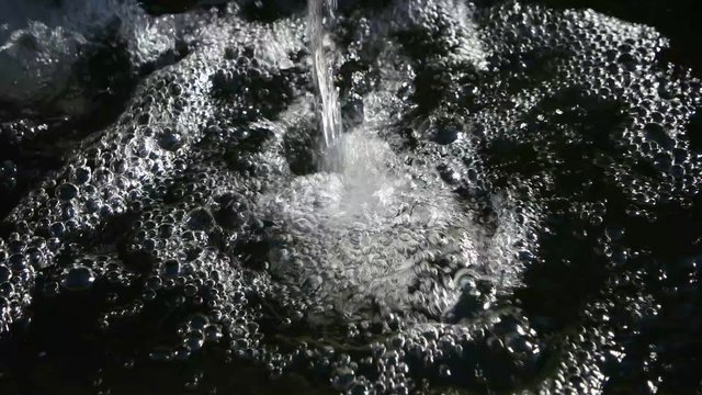 Stream of water pouring into bowl or pool. Small arificial waterfall work