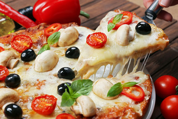 Delicious pizza and fresh vegetables on wooden background, close up