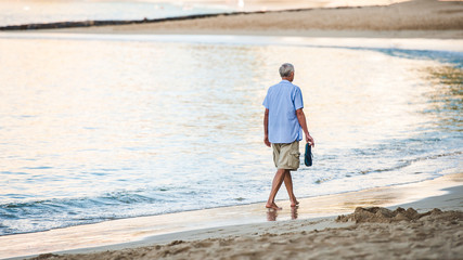 海岸を寂しく歩く中年の男性