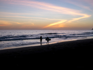 Surfers walks along the beach 