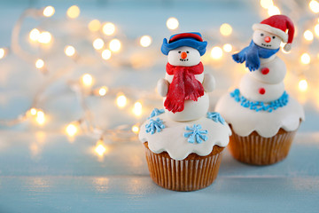 Christmas cupcakes with lights on background