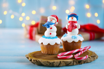 Christmas cupcakes with candies on wooden stand, closeup
