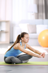 Young girl making fitness exercise indoors