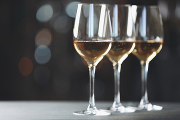 Glasses with white wine on blurred background