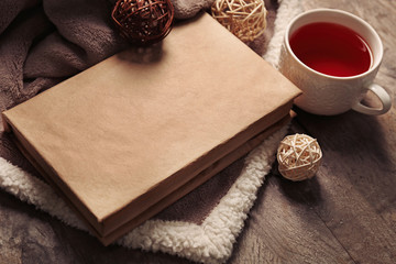 A book, a cup of tea, decorative balls and a blanket on the floor, close-up