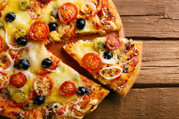 Delicious fresh pizza on wooden table, top view