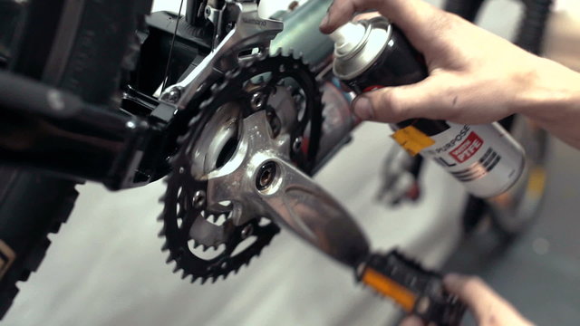 Spraying and cleaning crank arms in workshop. Bike repair