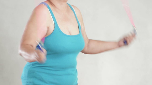 Obese woman doing a jump rope work out.