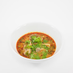 The tasty spicy pork tom yum soup (hot and sour soup) in white ceramic bowl, homemade Thai food.