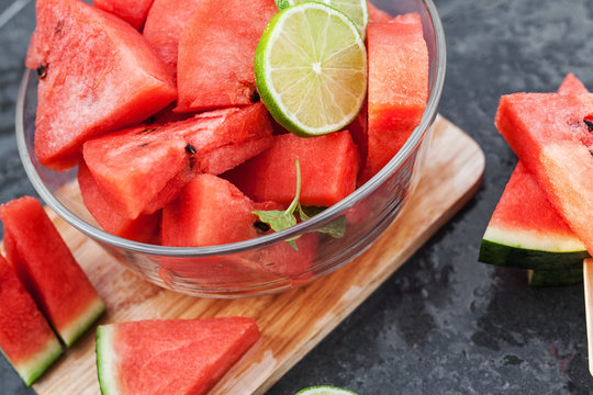Watermelon slices with lime on black table