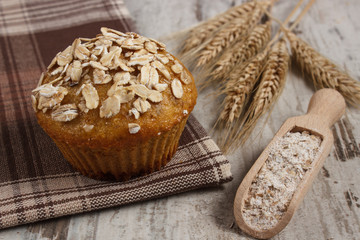 Fresh muffin with oatmeal, rye flour and ears of rye grain, delicious healthy dessert