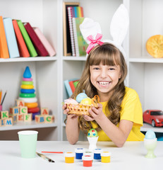 Little girl dressed in bunny ears with Easter eggs