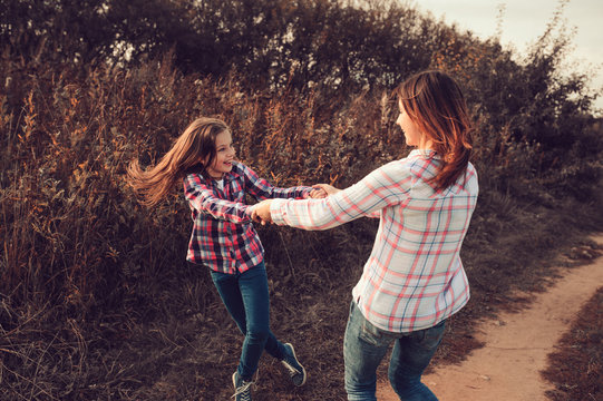 happy mother and daughter on the walk on summer field. Family spending vacation outdoor, lifestyle capture, cozy mood.