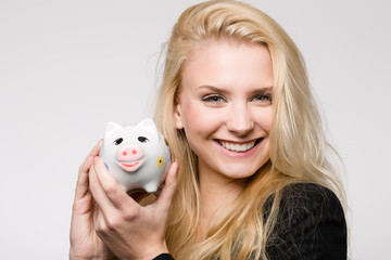 Hübsches fröhliches Mädchen mit Sparschwein