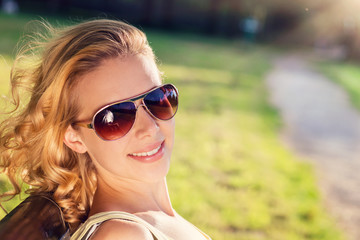 Young woman wearing sunglasses in sunny summer nature