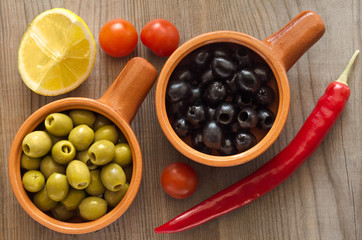 Olives in cups on a wooden table
