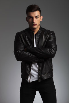 man in leather jacket pose standing with hands crossed