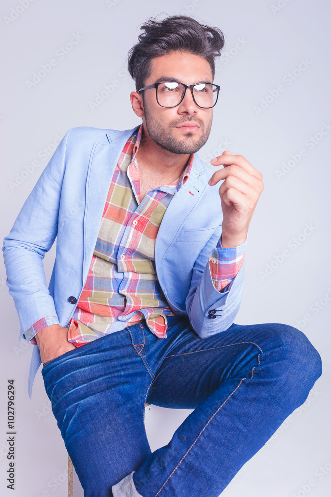 Wall mural casual man wearing jeans and glasses seated