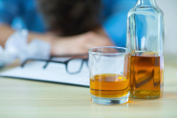 Drunk man drinking alcohol while working  