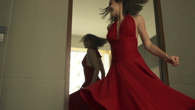 Young, beautiful woman checking her appearance in front of the mirror
