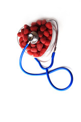 Blue stethoscope and red raspberries shaped in heart