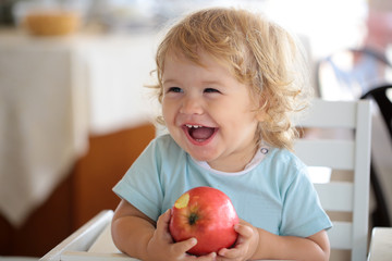 Laughing baby boy with apple
