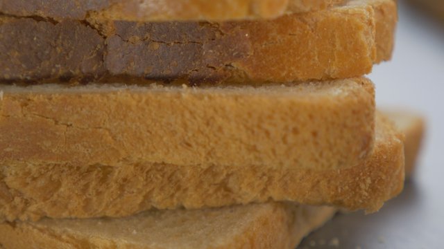 Bread pieces on table top close-up slow tilting 4K 2160p UltraHD footage - Toast bread on table slow tilting 4K 