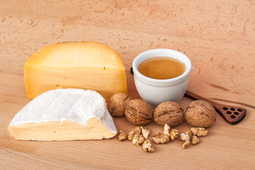 Fototapeta na wymiar Cheese, walnuts, honey on a wooden table