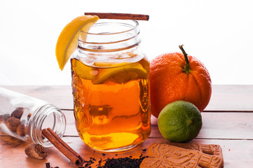 Hot spiced tea in jar on wooden table