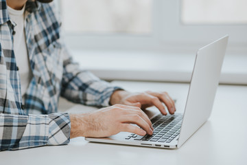 man typing on laptop computer