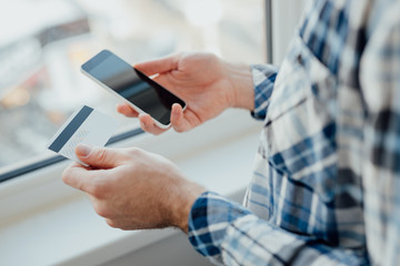 Man hands holding card and smart phone