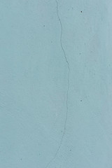 Grunge Background. Wall with the colored turquoise whitewash falling off fragment as a background texture