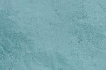 Grunge Background. Wall with the colored turquoise whitewash falling off fragment as a background texture