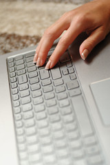 Woman's fingers on the laptop keyboard in the office