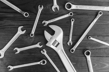 Adjustable wrench and small wrench on wooden background